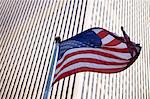 American flag flying by city skyscraper