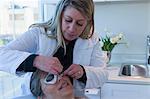 Doctor placing patches on patient's eyes