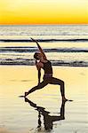 Woman practicing yoga on beach