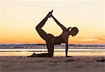 Woman practicing yoga on beach