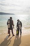 Scuba divers walking on tropical beach