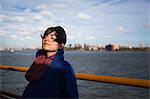 Woman on ferry in urban harbor