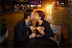 Kissing couple having pizza outdoors