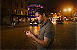 Man using cell phone on city street