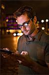 Man using tablet computer on city street