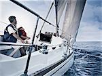 Father and son steering boat on water