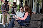 Couple using tablet computer on porch