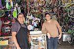 Mechanics smiling in bicycle shop