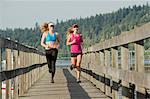 Teenage girls running on wooden dock