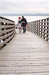 Couple walking on wooden dock