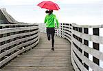 Woman running under umbrella