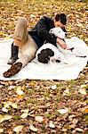 Man and dog relaxing on picnic blanket