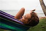 Woman relaxing in hammock on beach