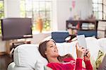 Woman using digital tablet on bed