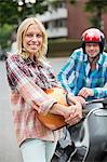 Smiling woman holding scooter helmet