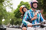 Couple riding scooter together outdoors