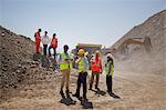 Business people and workers talking in quarry