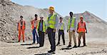 Business people and workers standing in quarry