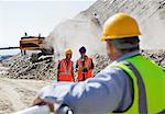 Businessman watching workers in quarry