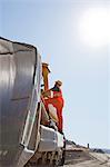 Worker climbing machinery in quarry