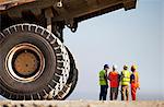 Workers talking by machinery on site