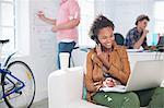 Businesswoman taking notes on phone in office