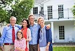 Family smiling together outside house