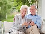 Couple using digital tablet together on porch swing