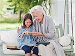 Woman giving granddaughter present in porch swing