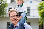 Father carrying son on shoulders outdoors