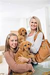 Mother and daughter holding dogs in vet's surgery