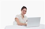 Smiling businesswoman using a notebook against a white background