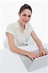 Portrait of a businesswoman using a laptop against a white background