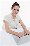 Portrait of a smiling businesswoman using a laptop against a white background