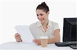 Happy businesswoman looking a document against a white background