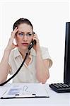 Portrait of a worried manager making a phone call while looking at statistics against a white background