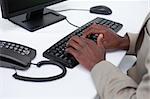 Close up of masculine hands typing with a keyboard against a white background