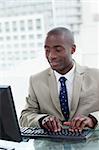 Portrait of a happy office worker using a computer in his office