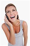 Portrait of a delighted woman making a phone call against a white background
