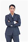 Serious businesswoman with folded arms against a white background