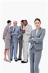 Tradeswoman with folded arms and colleagues behind her against a white background