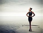 Elegant black girl with a black dress standing on a pier