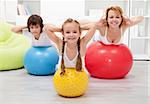 Kids and woman doing gymnastic at home - with large balls