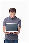 Young man showing screen of his notebook against a white background