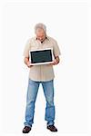 Mature male showing his laptop screen against a white background