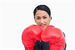 Close up of confident saleswoman with boxing gloves against a white background