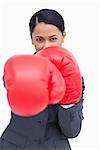 Close up of saleswoman with boxing gloves attacking against a white background
