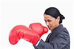 Close up side view of aggressive saleswoman with boxing gloves against a white background