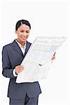 Close up of smiling saleswoman reading the news paper against a white background