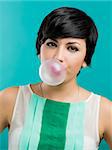 Portrait of a beautiful girl with a bubble gum on the mouth, against a blue background